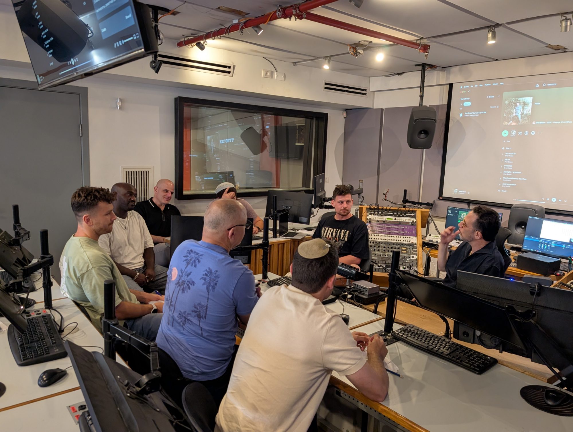Gilad Kahana speaking with the group seated around the control room