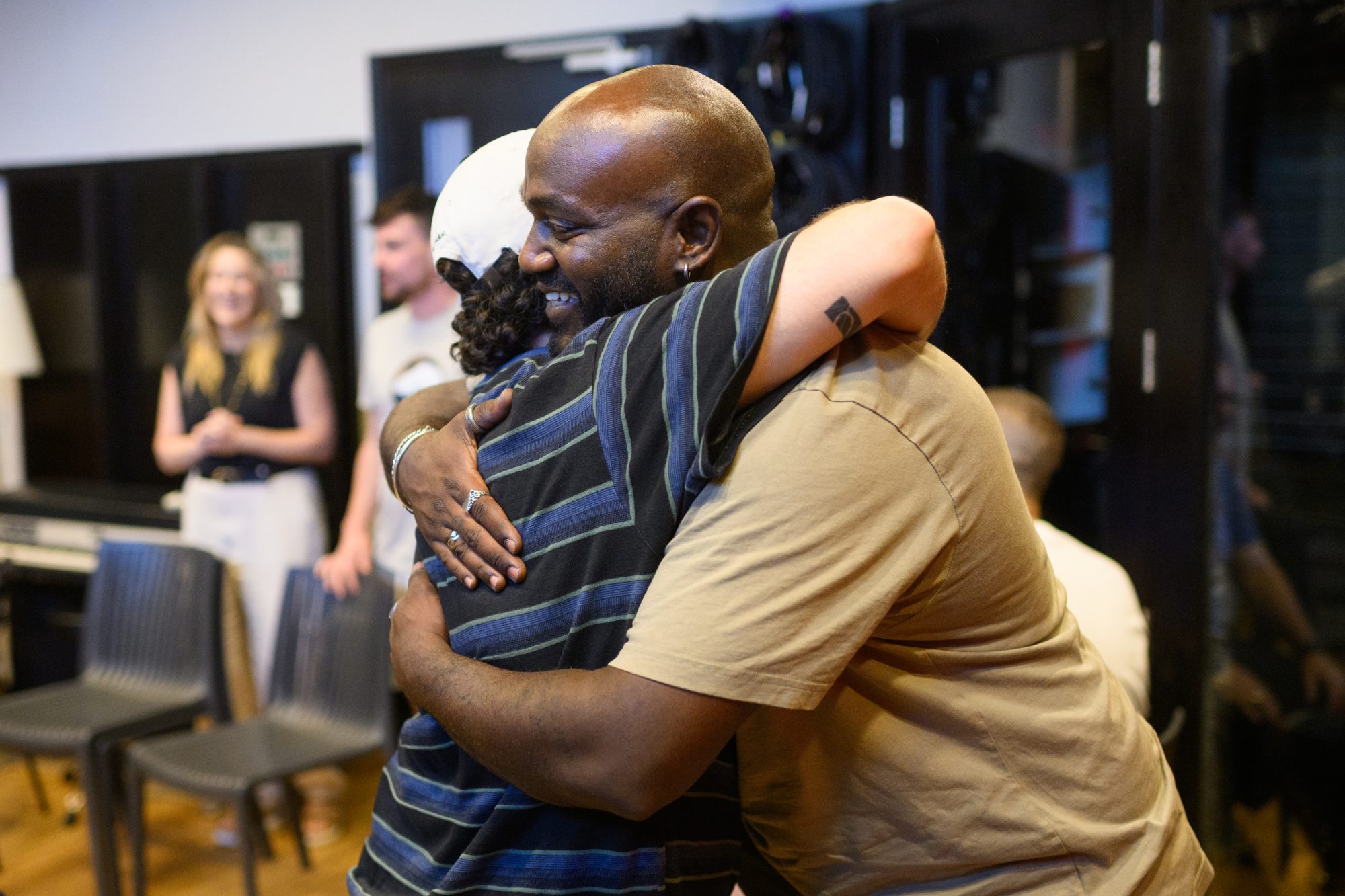 Black-and-white photo of two participants embracing after a session